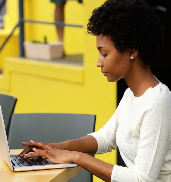 attractive-young-woman-using-laptop-outside-P9RLFGU-721x817